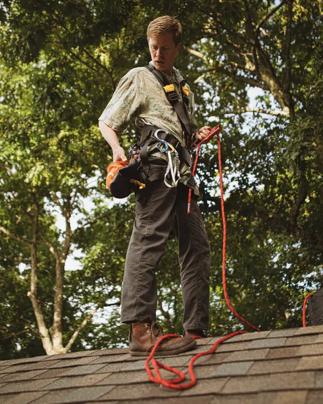 Roofer in a safety harness on a residential roof